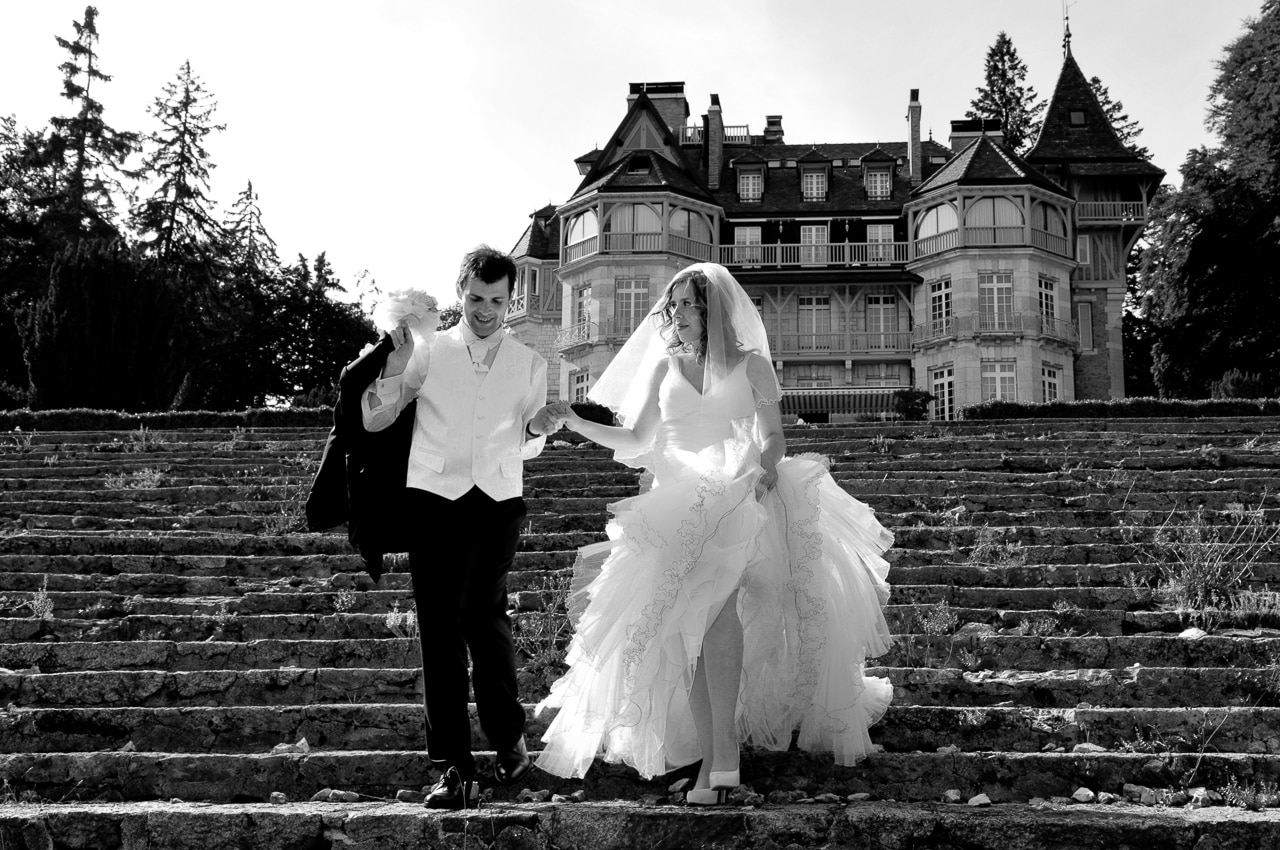 Portait en noir et blanc des mariés devant le château des Avenières