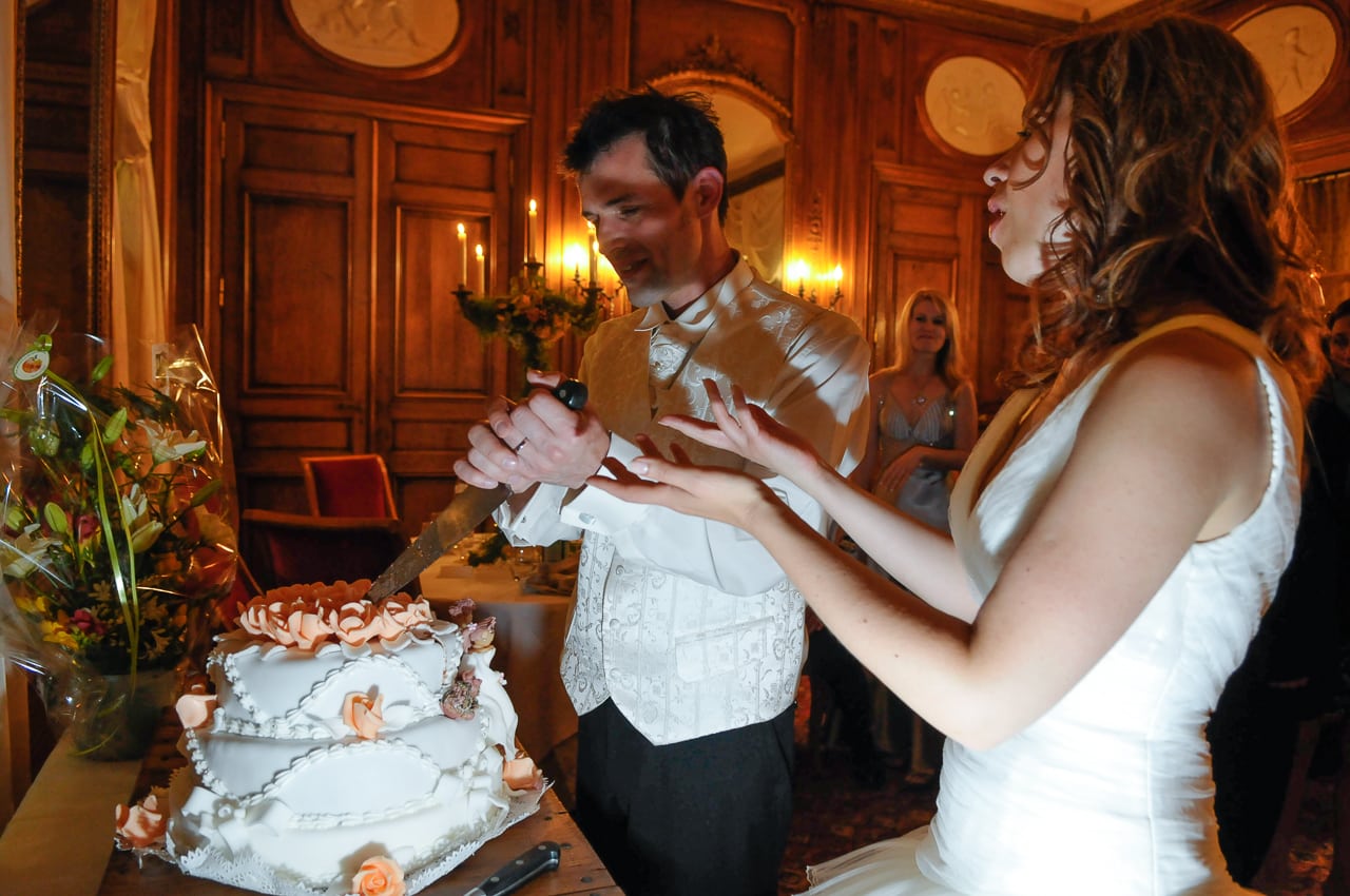 Marié coupant le gâteau de mariage